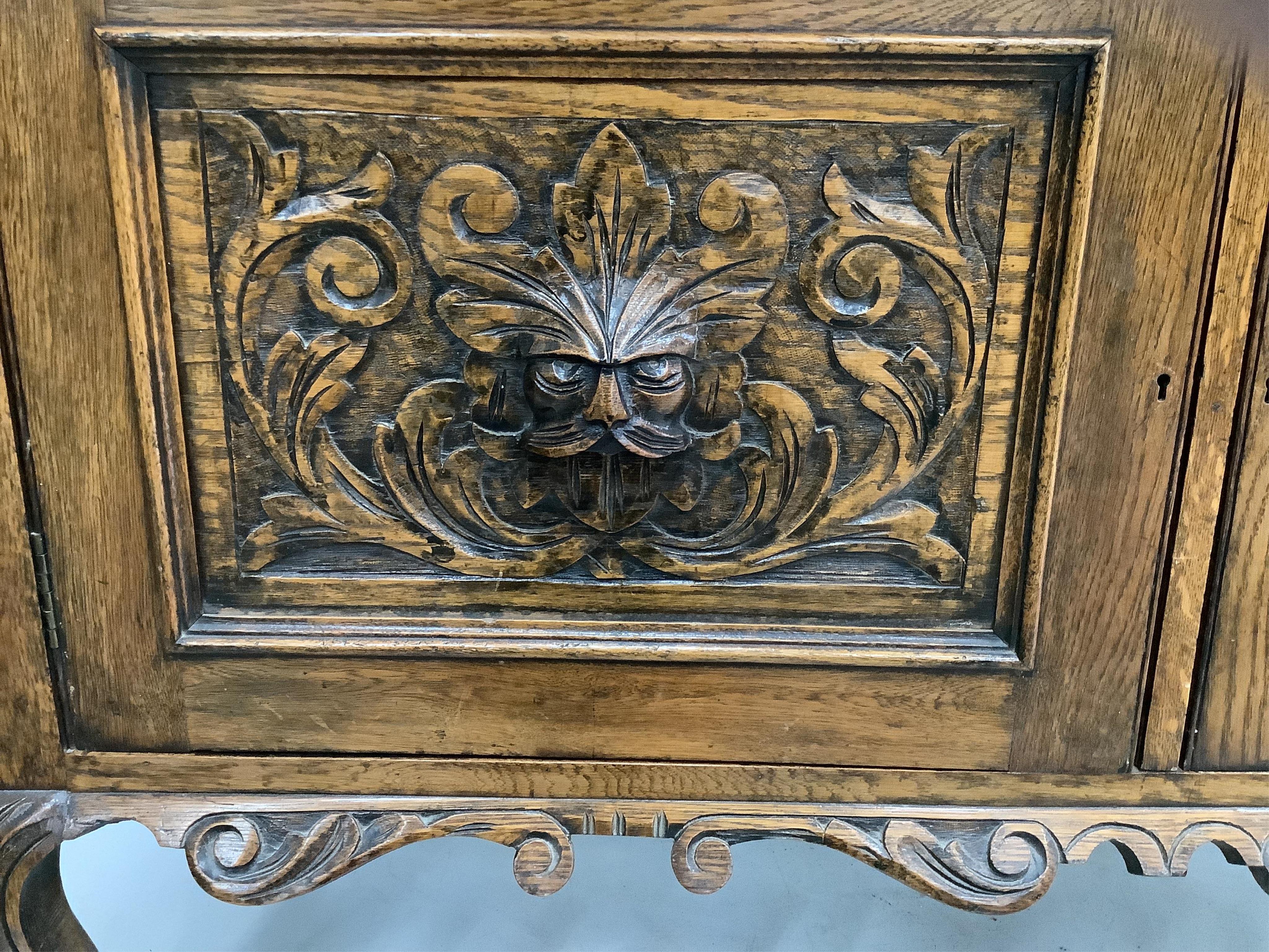 An early 20th century Flemish carved oak bow front dresser, width 138cm, depth 50cm, height 185cm